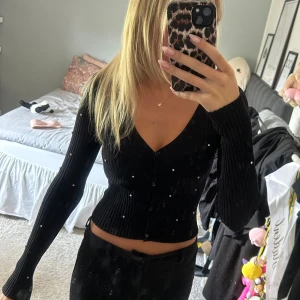 Svart ribbad kofta med pärlor -  svart ribbad kofta från H&M med v-ringning och knappar framtill