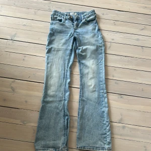 Ljusblå bootcut jeans från Lindex - Säljer ett par ljusblå jeans från Lindex i modellen Freja. Jeansen har bootcut-ben och klassisk femficksdesign. De är tillverkade i bomull och har snygga slitningar framtill för en cool look.