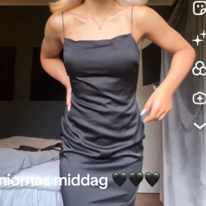 Svart långklänning med öppen rygg - Säljer nu min älskade balklänning 🥹En supersnygg svart långklänning med tunna axelband och öppen rygg. Klänningen har en slät, glansig yta och figurnära passform som ger en elegant siluett. Perfekt för dig som vill sticka ut med en stilren look. 