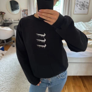 Svart Nike sweatshirt med drip-logga - Svart sweatshirt från Nike med tre vita drip-Swoosh loggor på bröstet. Klassisk rund halsringning och långa ärmar.😇