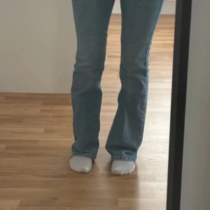 Blå bootcut jeans New Look Brooke - Säljer ett par ljusblå jeans från New Look, modell Brooke Petite. Jeansen har bootcut passform med lätt utsvängda ben och klassisk femficksdesign. Tillverkade i bomull med en snygg tvättad look. .