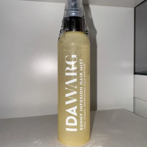 Ida Warg Sunny Infusion Hair Mist - Fräsch hårparfym från Ida Warg i en ljusgul plastflaska med sprayfunktion. Sunny Infusion Hair Mist är 100% vegansk och ger håret en uppfriskande doft. Perfekt för dig som vill ha en lätt och somrig känsla i håret. Flaskan innehåller 100ml och är oöppnad, den kan eventuellt vara provad 1 gång och kan ha varit öppnad i butik.