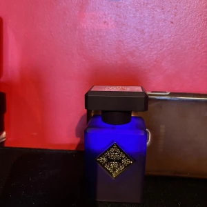 Initio Side Effect Eau de Parfum 50ml - Initio Side Effect Eau de Parfum i en lyxig, matt mörkblå flaska med fyrkantig form och elegant gulddetalj framtill. Rymmer 50 ml och är tillverkad i Frankrike. Ca 60-70% kvar, söker efter en ny doft (byte) då jag inte fått användning av denna lyxiga doft