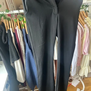 Svarta raka kostymbyxor - Svarta kostymbyxor med rak passform och klassisk look. Byxorna har hög midja och är sydda i ett mjukt tyg som ger en dressad känsla. Perfekta att styla med en skjorta eller stickad tröja för en clean vibe.