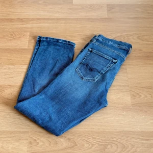 Blå Replay jeans thad - Snygga blå jeans från Replay i storlek 158 eller 14A. Jeansen har tydliga Replay-detaljer på bakfickan och vid myntfickan. Tillverkade i slitstarkt denim med en skön passform som funkar till allt.