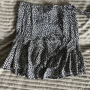 Söt mörkblå kjol med vita blommor - Säljer denna jätte söta kjol då den är för liten! den är i storlek 122/128 men skulle säga att den passar folk som har 152 i byxor. Väldigt strechig. Har tyvärr ett hål men det täcks över av kjolen. Oklart vart den är ifrån.