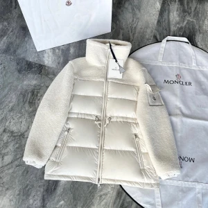 Moncler Damjacka  - Snygg vit pufferjacka från Moncler med teddyärmar och hög krage. Jackan har dragkedja framtill, snörning i midjan och praktiska fickor. Moncler-logga på ärmen och cool mix av glansigt material och mjuk teddy. Perfekt för kalla dagar när du vill sticka ut. Kontakta via Snapchat: maisonla_dripponför eventuella rabatter på denna produkt
