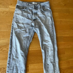 Ljusgrå loose fit jeans Jack & Jones - Säljer ett par ljusgrå loose fit jeans från Jack & Jones, modell Chris. Klassisk femficksdesign, raka ben och relaxed passform. Jeansen är tillverkade i bomull och har en snygg tvättad look. Perfekta för en chill och avslappnad stil.