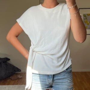 Vit stickadtopp med knyt i sidan - Snygg stickadtopp med knyt i sidan