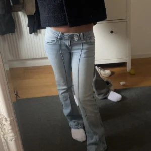 Ljusblå bootcut jeans low rise  - Säljer ett par ljusblå jeans med bootcut-modell och låg midja. Jeansen har klassiska fickor och markerade sömmar framtill. Perfekta för dig som gillar en retro vibe och vill ha ett par snygga jeans med lite utsvängda ben.