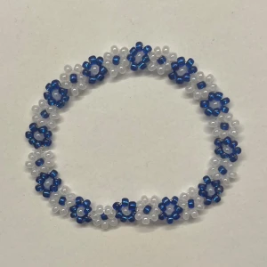 Blått och vitt pärlarmband med blommor - Handgjort armband med små blå och vita pärlor formade som blommor. Perfekt inför sommaren! Kan såklart göras i andra mönster och storlekar💞💞