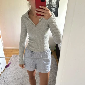 Ljusgrå ribbad tröja med half zip - Supersnygg ljusgrå ribbad tröja från Bik Bok med lång ärm och half zip-dragkedja framtill. Tröjan är tight i modellen och har en mjuk, stretchig känsla. 