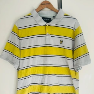 Randig pikétröja från Lyle & Scott - Säljer en snygg och avslappnad pikétröja från Lyle & Scott i storlek xxl. Tröjan har ett fräscht randigt mönster. Den har korta ärmar och en klassisk krage med knappar. Perfekt för sommardagar eller en avslappnad stil.