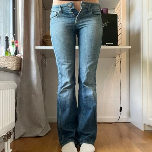 Blå bootcut jeans från Miss Sixty - Snygga blå jeans från Miss Sixty med bootcut-modell och låg midja. Jeansen har klassiska fem fickor, dragkedja och knapp framtill samt coola Miss Sixty-detaljer. Tillverkade i jeansmaterial med lätt slitning för en avslappnad vibe. Innebenslängden är 82cm, ytterbenslängden 101cm och midjan är 37-38cm!! Jag är 170 och säljer då de är tajta på mig🫶