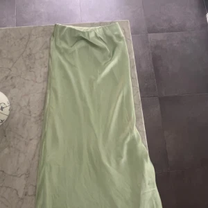 Ljusgrön långkjol från Bianca Nelly - Snygg ljusgrön långkjol från Biancas kollektion med Nelly i slätt och glansigt material. Kjolen har en enkel och stilren design med rak passform, och superskön!! 