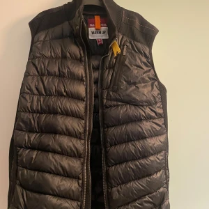 Parajumper väst - Parajumper väst i använt skick. De två sista bilderna visar defekter inuti väst och på ryggen, ett litet hål. Hör av dig vid intresse för mer bilder!