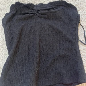 Säljer massa toppar från shein för 15 kr st. Svart bandeau tubtopp med rynk - Säljer en svart bandeau tubtopp med smockad struktur och rynkdetalj upptill. Använd 1 gång.  Säljer massa toppar från SHEIN för 15 kr st så gå gärna in på min profil och kika. Strl xs. 