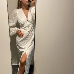 Vit långklänning med broderi och slits - Superfin vit långklänning med broderade blommor och puffärmar från shein🤍skönt material och otrolig passform. Tyvärr för stor för mig därav säljer jag den.