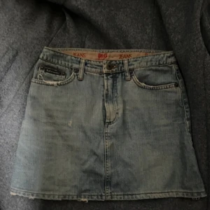 Jeanskjol från D&G i ljusblå denim - Snygg kort jeanskjol från Dolce & Gabbana i ljusblå denim. Klassisk femficksmodell med bälteshällor, knapp och dragkedja framtill samt D&G-lapp bak. Perfekt för dig som gillar vintagevibbar och streetstyle. Riktigt fint märke. storleken är 24/38 vilket jag tror motsvarar xs men är inte helt 100.