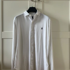 Ralph Lauren skjorta - Stilren vit KNIT DRESS SHIRT från Ralph Lauren. Skjortan har en qr kod som man kan scanna för äkthet. Produkten är också i mycket bra skick. Hör av er vid frågor och funderingar!