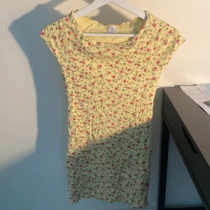 Gul blommig kortklänning - Supersöt gul kortklänning från Lindex med små rosa och gröna blommor. 