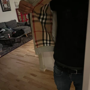 Grå zip-hoodie från Burberry, S, (A-Kopi) - Grå hoodie från Burberry med dragkedja och klassiskt rutigt foder på insidan. Mjuk bomullskänsla, två fickor fram och snygga ribbade muddar. Perfekt för dig som vill ha en stilren hoodie med lyxig touch och ikoniskt mönster.