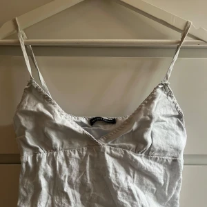 Ljusblå linnetopp från Brandy Melville - Supersöt ljusblå linnetopp från Brandy Melville med smala justerbara axelband och v-ringning. Toppen har en snygg knytning i ryggen och är tillverkad i ett luftigt linnematerial, perfekt för varma dagar.