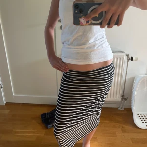 Svartvit randig långkjol - Säljer en svartvit långkjol med horisontella ränder. Kjolen har en tight passform och är low waist. Knappt andvänd💞