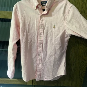 Ralph Lauren Skjorta - Säljer en riktigt snygg rosa skjorta ifrån Ralph Lauren som är slim fit stretch Oxford, mitt pris är 499 men det är inte ristat i sten.