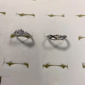 925 Silverpläterade Strass Par ringar - Fyra snygga Silverpläterade ringar i olika designer. En med gnistrande stenar, en med tvinnad look och två med ingraverad text och små stenar. Perfekta för att mixa och matcha för en personlig stil.  Med stämpel, 155kr/par , helt ny 