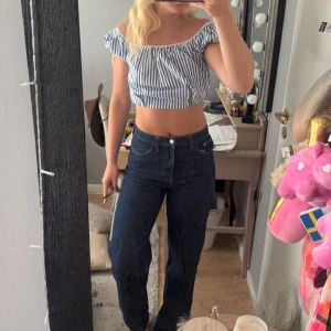 Mörkblå raka jeans - Säljer ett par mörkblå jeans med raka ben och hög midja. Klassisk femficksmodell med snygga kontrastsömmar. Jeansen har en enkel och clean look som passar till det mesta. Materialet är kraftigt denim i bomull.