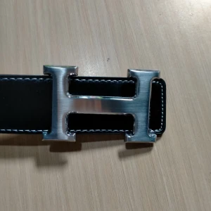 Svart skärp med H-spänne i silver - Stilrent svart bälte i skinn med ett stort H-format spänne i silverfärgad metall. Bältet har vit kontrastsöm längs kanterna och klassisk design som sticker ut. Perfekt accessoar för att lyfta din outfit med en lyxig touch. Vid fundering är det bara att skicka dm :)