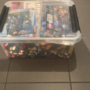 Stor låda med LEGO och byggsatser - Säljer en stor genomskinlig plastlåda fylld med blandade LEGO-bitar och flera byggsatser från LEGO och Kre-O. Inkluderar manualer till bland annat Star Wars, Creator, Transformers och olika fordon. Perfekt för dig som gillar att bygga och skapa egna modeller.