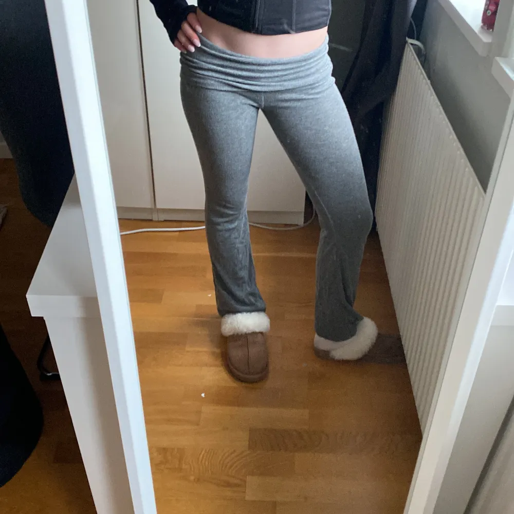 Gråa mjukisbyxor från Gina Tricot med låg midja och utsvängda ben. Byxorna är i mjukt bomullsmaterial och har en bekväm passform som sitter snyggt över höfterna. Perfekta för en avslappnad stil.. Farkut & Housut.