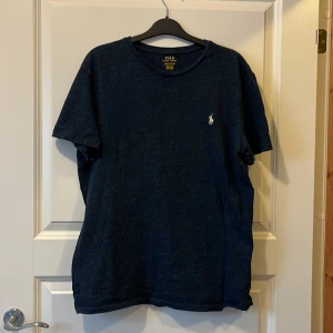 T-shirt från Polo Ralph Lauren - T-shirt från Polo Ralph Lauren med loggan på bröstet. Go färg, basic och bra tröja. Perfekt för en stilren och enkel look fast med lite vintage toner.   Den är i bra skick. Inga skador eller slit. Köpte den på second hand för något år sedan men används nästan aldrig av mig. Hör av dig och du har frågor eller funderingar.