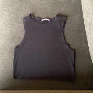 Svart ribbad linnetopp från Zara Trafaluc - Säljer en svart ribbad linnetopp från Zara Trafaluc i storlek S. Toppen är ärmlös med rund halsringning och har en croppad passform. Perfekt att styla till olika outfits!