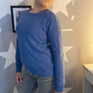 Blå stickad tröja från VILA - Mysig blå stickad tröja från VILA med rund halsringning och ribbade muddar vid ärmslut och nederkant. Perfekt för lager-på-lager och enkel att matcha med jeans eller kjol.