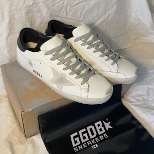 Golden Goose sneakers vita - Säljer ett par vita Golden Goose Superstar sneakers. Klassisk och stilren design. Storlek 41 men passar även 42. Priset är ej hugget i sten!