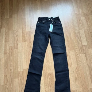 Svarta high waist jeans med slits - High waist slit jeans från ginatricot säljes då dem är lite för korta på mig, aldrig använda endast testade, lappar sitter kvar, strl 32, köpare står för ev frakt, nypris 499kr