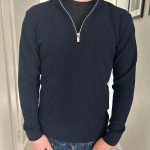 Mörkblå stickad tröja med dragkedja - Stickad tröja med half zip från jack and jones. Snygg och bra passform. Passar till mycket.
