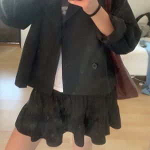 Svart volangkjol - Säljer en svart kortkjol med volangdetaljer. 