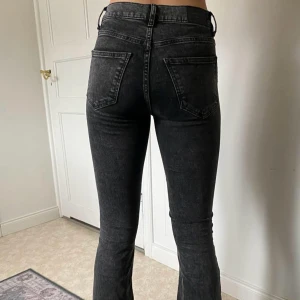 Svarta low waist bootcut jeans - Säljer ett par svarta bootcut jeans med låg midja. Jeansen har klassiska fem fickor, bälteshällor och stängs med knapp och dragkedja. Snygg tvätt och passar perfekt till många olika stilar.