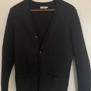 Svart cardigan från J.Lindeberg - Säljer en klassisk svart cardigan från J.Lindeberg i 100% ull. Hör av er vid frågor