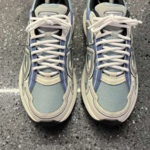  Dior skor - Säljer ett par snygga sneakers från Dior i blått, grått och vitt. Skorna har tydliga CD-loggor på sidan, hälen och sulan. Ovandelen är i mesh och syntet med vita snören och svart insida. Perfekta för dig som gillar exklusiva och trendiga sneakers.