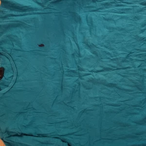 Turkos t-shirt från Polo Ralph Lauren - Turkos t-shirt från Polo Ralph Lauren med klassisk rund hals och liten broderad logga på bröstet. Perfekt för en avslappnad stil och enkel att matcha med jeans eller shorts.