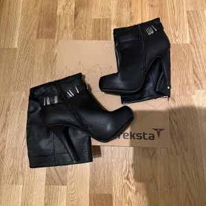 Svarta Stövlar, Storlek 38 - Svarta stövletter med dragkedja och silver detaljer från varumärket Treksta till salu. Helt ny aldrig använd, storlek 38. Hör av er för mer info/bilder eller funderingar. PRIS KAN DISKUTERAS!