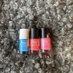 Tre nagellack från Ztiz i olika färger - Säljer tre nagellack från Ztiz i färgerna blå, korallröd och rosa. Två av flaskorna har svart lock och en har vitt lock. Perfekt för dig som vill variera din nagellook med starka färger.
