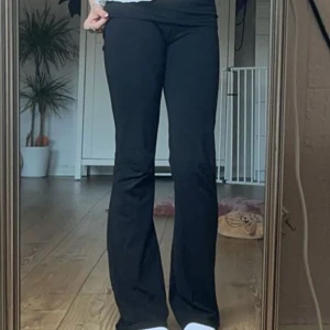 Svarta yoga pants - Säljer ett par svarta bootcut byxor med hög midja. Byxorna har en klassisk passform som sitter tajt upptill och släpper ut vid benen. Perfekta att styla med sneakers eller boots.