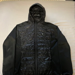 Svart cardigan - Säljer en svart cardigan från Cross Sportswear i storlek XL men passar L/M. Knappt använd. Köpt för 900kr.