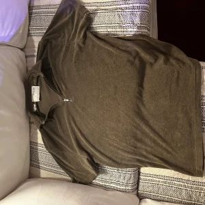 Grön pikétröja med dragkedja från Selected Homme - Säljer en grön pikétröja från Selected Homme med korta ärmar och snygg dragkedja vid halsen. Tröjan har en klassisk passform och är tillverkad i mjuk bomull. Perfekt för en stilren och avslappnad look för sommaren!